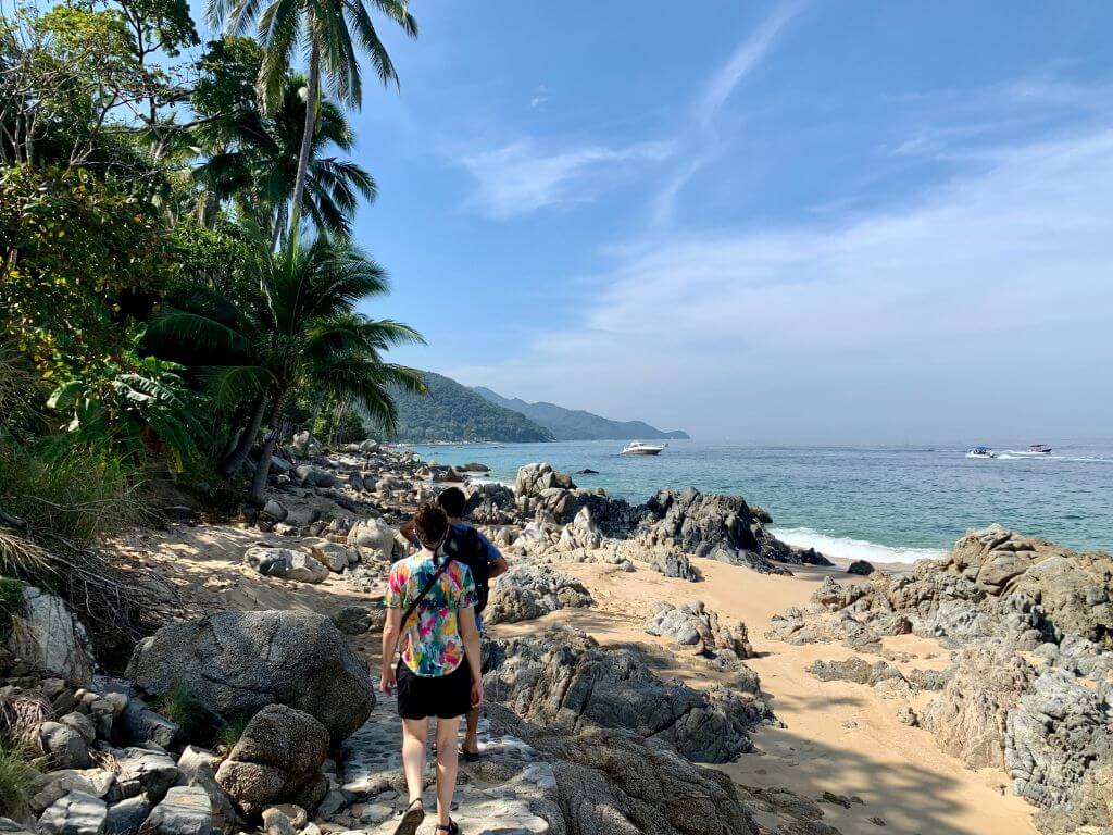 hiking to Las Animas beach along a concrete path on the rocky and sandy shore