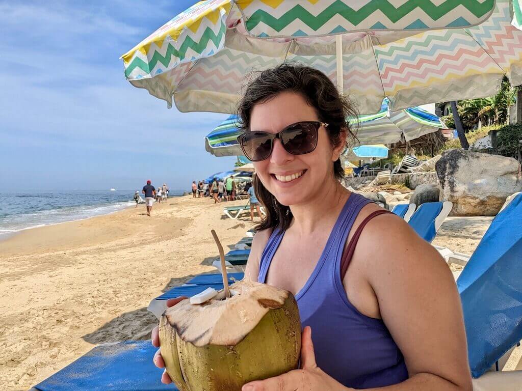 Janine enjoying a cold coconut on the beach in Puerto Vallarta